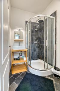 uma casa de banho com um chuveiro e um lavatório. em Thomas, F2 moderne au coeur de la Bouille em La Bouille
