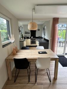 cocina y comedor con mesa de madera y sillas en Oosterschelde Lodge met veel privacy en dicht bij het water, en Scherpenisse