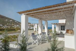 a patio with a table and chairs under a pergola at Casa Rakan in Naxos Chora