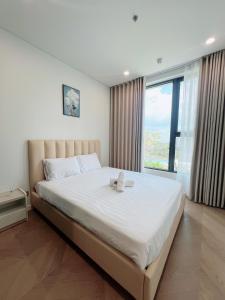 a bedroom with a large white bed with a window at THE LUMIÈRE RIVERSIDE LUXURY SUITE in Ho Chi Minh City