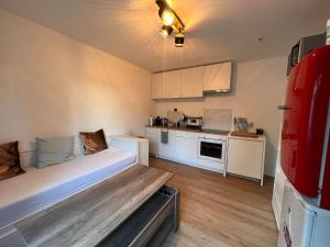 ein kleines Zimmer mit einem Bett und einer Küche in der Unterkunft Ferienzimmer Schlüter in Neulußheim