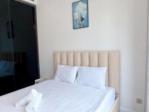 a white bed with white sheets and pillows at THE LUMIÈRE RIVERSIDE LUXURY SUITE in Ho Chi Minh City