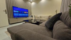 a living room with a couch and a flat screen tv at Rose in Riyadh