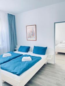 a bedroom with two beds with blue pillows at Stay Westend in Wetzlar