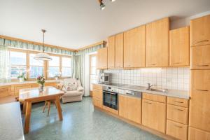 cocina con armarios de madera, mesa y comedor en Haus Holzer, en Sankt Andrä im Lungau