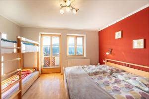 1 dormitorio con 2 literas y paredes rojas en Haus Holzer, en Sankt Andrä im Lungau
