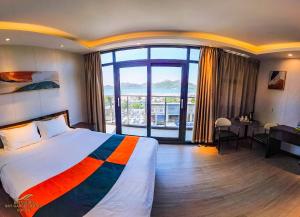 a hotel room with a bed and a large window at Sky Garden Hotel in Coron