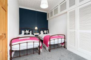 1 dormitorio con 2 camas y pared azul en Bishop's Little Palace en Bishop Auckland