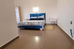 um quarto com uma cama azul num quarto branco em ILY House : Villa de plage avec piscine sans vis-à-vis. em Bejaïa