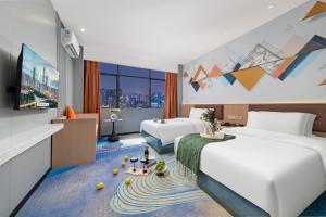 a hotel room with two beds and a flat screen tv at Xinghe Yuezhi S Hotel to Guangzhou Yuexiu Park Railway Station Subway Station Baima Clothing City Flagship Store in Guangzhou