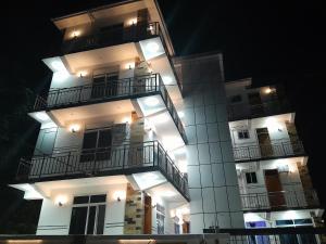 een hoog wit gebouw met balkons in de nacht bij DODOMA WHITE HOTEL in Dodoma