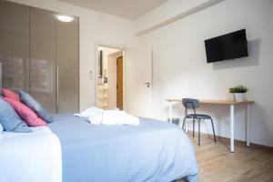 - une chambre avec un lit, un bureau et une télévision dans l'établissement Tiburtina Home, à Rome