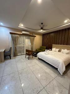 a bedroom with a large white bed and a desk at Hotel Banyan Tree Yeshwanthpur in Bangalore