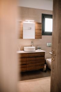 La salle de bains est pourvue d'un lavabo et de toilettes. dans l'établissement Konatsi Luxury Apartments, à Tyros