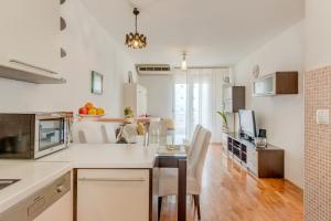 eine Küche und ein Esszimmer mit Tisch und Stühlen in der Unterkunft Comfy & Urban apartment on Žnjan near beach in Split