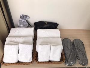 due cestini pieni di asciugamani e scarpe in un armadio di Green Hotel - Chiayi a Città di Chiayi