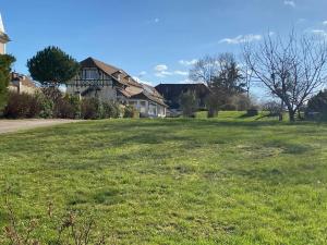 un gran campo de césped verde frente a las casas en Les Hôtes de Sermaize, en Bois-le-Roi