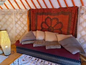 - un lit dans une tente avec des oreillers et un tapis dans l'établissement Les Hôtes de Sermaize, à Bois-le-Roi