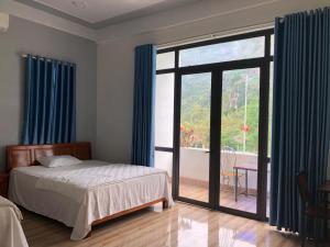 a bedroom with a bed and a large window at Nam Anh Hotel in Phong Nha