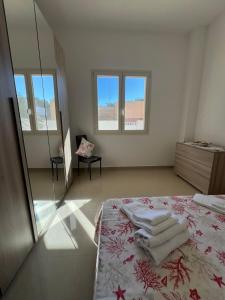 ein weißes Zimmer mit einem Bett und Handtüchern darauf in der Unterkunft Aurora e Alba in Casalabate