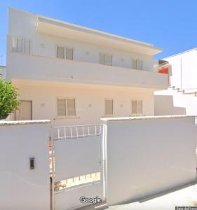 ein weißes Gebäude mit einer großen offenen Garagentür in der Unterkunft Aurora e Alba in Casalabate