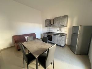 a kitchen with a table and chairs and a refrigerator at Aurora e Alba in Casalabate