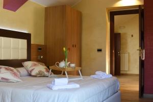 - une chambre avec un lit et une table avec des serviettes dans l'établissement Hotel Monte Campo, à Capracotta