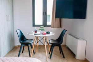stół i krzesła w pokoju z oknem w obiekcie Konatsi Luxury Apartments w mieście Tyros