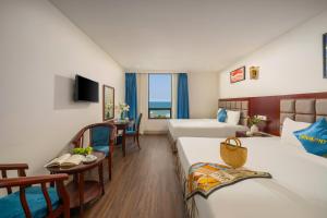 Un pat sau paturi într-o cameră la SeaFront Hotel DaNang
