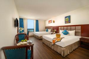 Un pat sau paturi într-o cameră la SeaFront Hotel DaNang