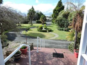a view of a garden from a balcony at Maple Lodge Motel in Matamata