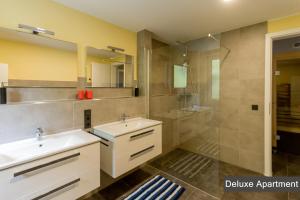 ein Bad mit 2 Waschbecken und einer Dusche in der Unterkunft Rurtal de luxe in Simmerath