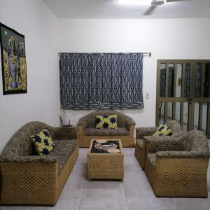 uma sala de estar com sofás e cadeiras e uma janela em Super Appartement à 10mn de la mer em Cotonou