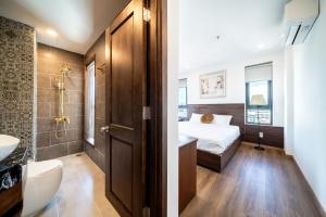 a bathroom with a bed and a toilet and a sink at Dian Hotel & Apartment in Danang +74 photos