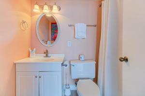a bathroom with a toilet and a sink and a mirror at 0514 Double The Pleasure by Atlantic Towers in Carolina Beach