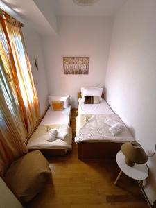 Duas camas num pequeno quarto com uma janela em Villa Elia em Káto Arkhánai