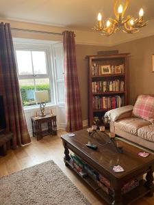 a living room with a couch and a coffee table at Thropton Demesne Farmhouse B&B in Rothbury