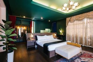 Un dormitorio con una cama grande y una pared verde en The Sea-Cret Garden Hua Hin en Hua Hin