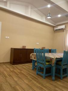 a dining room with a table and blue chairs at مزرعة المدائن in Madain Saleh