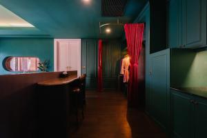 華欣的住宿－華欣海魁特花園酒店，厨房设有蓝色的墙壁和红色的窗帘