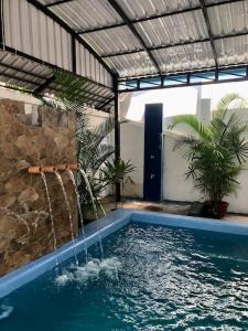 a swimming pool with a water fountain in a house at Villa Garden Apart & swimming pool in Kampot