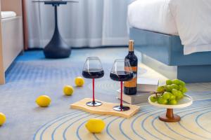 two glasses of wine and grapes on the floor at Xinghe Yuezhi S Hotel to Guangzhou Yuexiu Park Railway Station Subway Station Baima Clothing City Flagship Store in Guangzhou