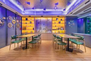 a restaurant with wooden tables and green chairs at Xinghe Yuezhi S Hotel to Guangzhou Yuexiu Park Railway Station Subway Station Baima Clothing City Flagship Store in Guangzhou