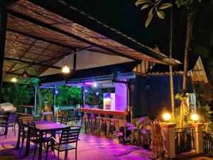 a restaurant with tables and chairs and purple lights at beautiful pool house in Patong Beach