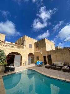 a house with a swimming pool in front of it at A la maison B&B in Xagħra