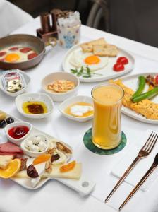 Impera Hotel - Special Category في إسطنبول: طاولة مع طعام الإفطار وكوب من عصير البرتقال