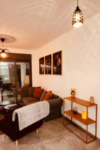 uma sala de estar com um sofá e uma mesa em דירת נופש נוף לכנרת em Migdal