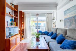 a living room with a couch and a tv at Apartamento Triana Los Remedios in Seville