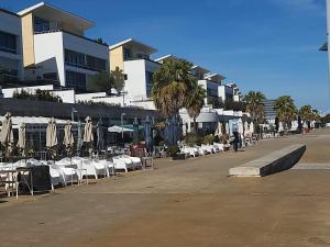 rzęd stołów i krzeseł z parasolami, stołami i krzesłami w obiekcie Private yacht, we love our guests w Lizbonie