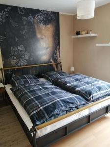 Bett in einem Zimmer mit einer Wand in der Unterkunft Ferienwohnung Wörrstadt in Wörrstadt